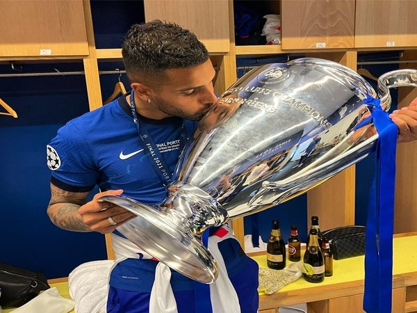 Emerson Palmieri mencium trofi Liga Champions yang ia menangkan bersama Chelsea musim ini / via Twitter