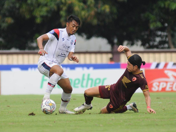 Pemain Arema FC, Rizky Dwi Febrianto dihadang pemain PSM Makassar Kenzo Nambu