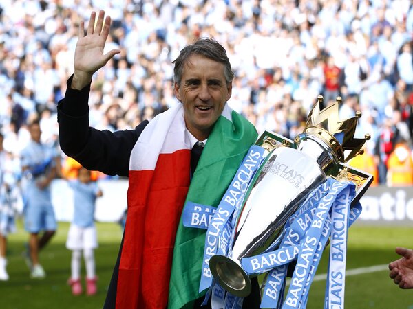 Roberto Mancini berpose dengan titel juara Premier League yang direngkuhnya bersama Manchester City di musim 2011/12 / via Getty Images