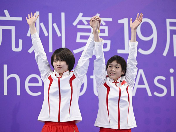 Peraih medali emas Quan Hongchan (kanan) dan Chen Yuxi dari China melakukan selebrasi setelah penganugerahan medali untuk menara 10 meter sinkronisasi putri di Asian Games Hangzhou. (Foto: Xinhua)