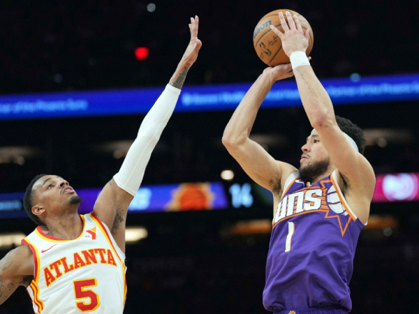 Devin Booker (kanan) mencetak 30 poin saat Phoenix Suns mengalahkan Atlanta Hawks 128-115 pada Kamis (21/3) malam. (Foto: AP)