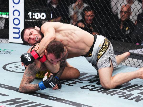 Islam Makhachev menyarangkan kuncian D'Arce choke untuk menghentikan perlawanan Renato Moicano. (Foto: UFC)