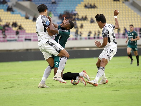 Penyerang PSS Sleman, Marcelo Cirino diapit pemain bertahan Bali United