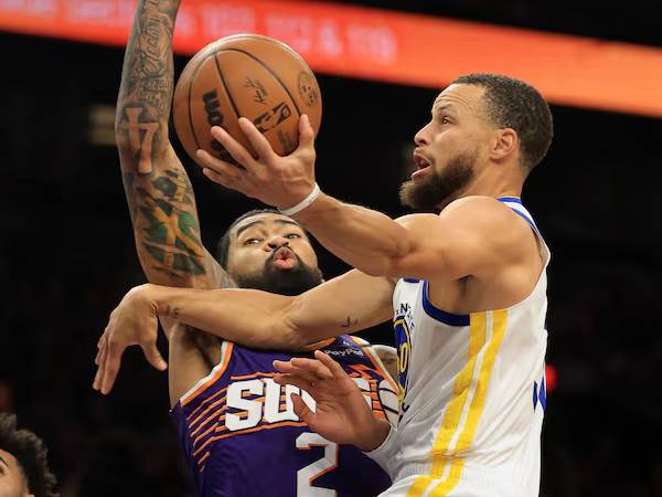 Stephen Curry (kanan) mencetak 25 poin saat tim tamu Golden State Warriors mengalahkan Phoenix Suns 133-95 pada hari Selasa (8/4) malam. (Foto: AP)