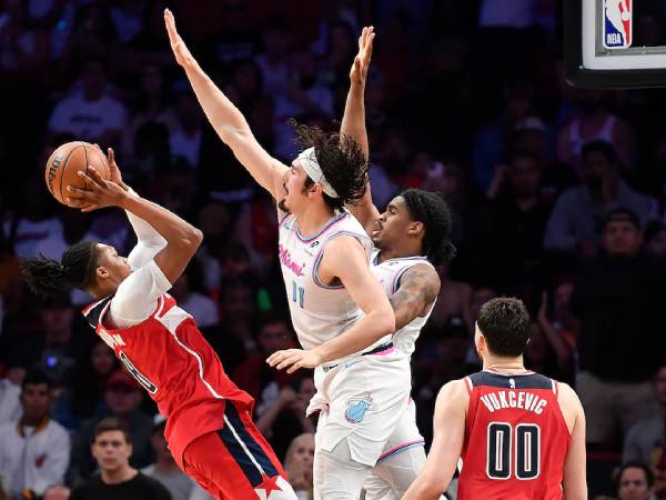 Bub Carrington (kiri) melesakkan tembakan floater meski dijaga ketat saat buzzer untuk membawa tim tamu Washington Wizards menang 119-118 atas Miami Heat pada Minggu (13/4).