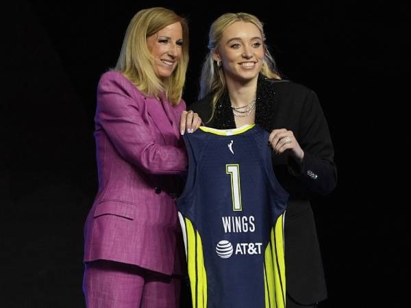 Paige Bueckers (kanan) berpose sambil memegang jersey Dallas Wings dengan Komisioner WNBA Cathy Engelbert. (Foto: AP)